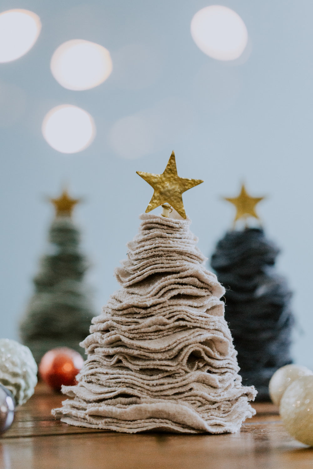Ethical fair trade upcycled stacked sweater Christmas tree handmade by Grain of Rice Project artisans in Kibera slum, Kenya | This tree is light gray in color and has a brass star topper.