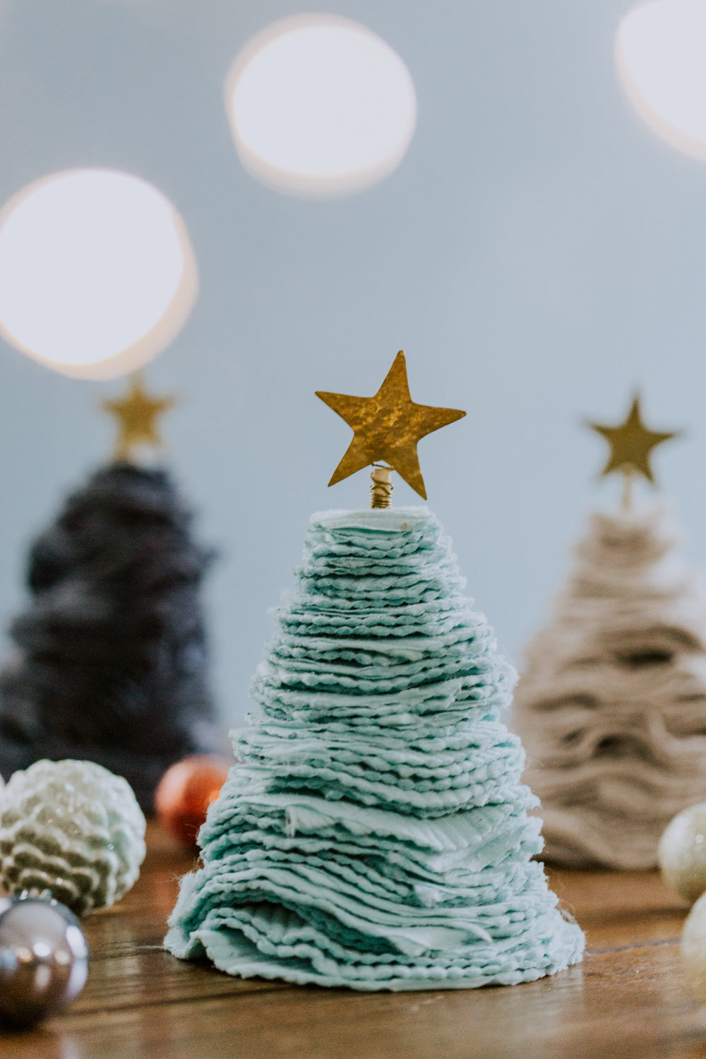 Ethical fair trade upcycled stacked sweater Christmas tree handmade by Grain of Rice Project artisans in Kibera slum, Kenya | This tree is aqua in color and has a brass star topper.