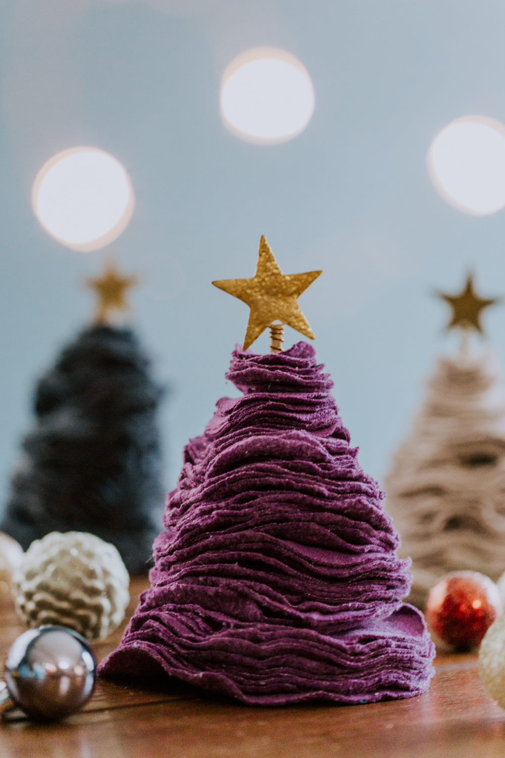 Ethical fair trade upcycled stacked sweater Christmas tree handmade by Grain of Rice Project artisans in Kibera slum, Kenya | This tree is purple in color and has a brass star topper.