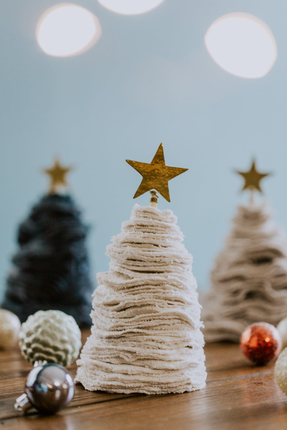 Ethical fair trade upcycled stacked sweater Christmas tree handmade by Grain of Rice Project artisans in Kibera slum, Kenya | This tree is white in color and has a brass star topper.